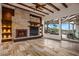 Cozy living room with a stone fireplace, exposed beams, recessed lighting, and backyard access at 10712 E Prospect Point Dr, Scottsdale, AZ 85262