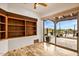 Sunlit living room with built-in shelving and sliding doors that open to an outdoor pool and patio area at 10712 E Prospect Point Dr, Scottsdale, AZ 85262