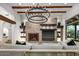 Elegant living room with a stone fireplace, built-in shelving, and a stylish chandelier at 10712 E Prospect Point Dr, Scottsdale, AZ 85262