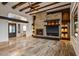 Open living room featuring stone fireplace, exposed beams, wood ceiling fan, and travertine floors at 10712 E Prospect Point Dr, Scottsdale, AZ 85262