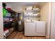 Functional laundry room with washer, dryer, shelving for storage, and modern water heater at 10906 W Boswell Blvd, Sun City, AZ 85373