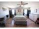 Bright main bedroom with a ceiling fan, ensuite bathroom, wood-look floors and abundant natural light at 10906 W Boswell Blvd, Sun City, AZ 85373