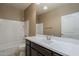 Bright bathroom featuring a large countertop, dark vanity, white tub, and a decorative mirror at 1203 E Judi St, Casa Grande, AZ 85122