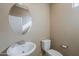 Well-lit half bathroom with a sink, toilet, and a large decorative oval mirror at 1203 E Judi St, Casa Grande, AZ 85122