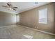 Spacious bedroom with neutral carpet, ceiling fan, and bright natural light from two windows at 1203 E Judi St, Casa Grande, AZ 85122