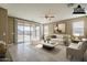 Bright living room featuring a neutral color palette, light tile floors, and a sliding glass door to the backyard at 1203 E Judi St, Casa Grande, AZ 85122