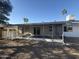 Exterior view of sunroom with a landscaped backyard and mature palm trees at 12415 W Rock Springs Dr, Sun City West, AZ 85375