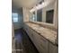 Bright bathroom featuring dual sinks, granite countertops, and white cabinetry at 12415 W Rock Springs Dr, Sun City West, AZ 85375