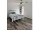 Bright bedroom featuring ceiling fan, window, and sleek metal-frame bed for a peaceful retreat at 12415 W Rock Springs Dr, Sun City West, AZ 85375