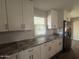 Beautiful kitchen featuring stainless steel refrigerator, granite countertops, and white shaker cabinets at 12415 W Rock Springs Dr, Sun City West, AZ 85375