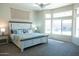 Spacious bedroom with large windows, carpeted floor, and a king-size bed at 13709 W Gunsight Dr, Sun City West, AZ 85375