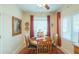 The dining room features wood table and chairs, red rug and curtains, and natural light from the window at 1885 E Sycamore E Rd, Casa Grande, AZ 85122