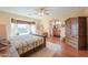 Comfortable main bedroom with wood floors, and a stylish armoire, leading to ensuite bath at 1885 E Sycamore E Rd, Casa Grande, AZ 85122