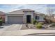 One-story home with gray exterior, stone accents, and landscaped front yard at 21370 N 260Th Ln, Buckeye, AZ 85396