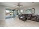 Living room with a brown leather couch and sliding glass doors leading to the backyard at 21370 N 260Th Ln, Buckeye, AZ 85396