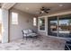 Covered patio with tiled floor, seating area, and sliding glass door leading to backyard at 21370 N 260Th Ln, Buckeye, AZ 85396