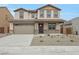 Charming two-story home featuring a neutral stucco exterior, a two-car garage, and a well-maintained front yard with minimal landscaping at 24216 W Agora Ln Ln, Buckeye, AZ 85326