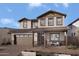 Two-story house with brown garage doors and stone accents at 24216 W Agora Ln Ln, Buckeye, AZ 85326