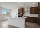 Modern kitchen featuring an island, stainless steel appliances, stylish espresso cabinets, and sleek tile flooring at 24216 W Agora Ln Ln, Buckeye, AZ 85326