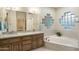 Bathroom featuring dual sinks, glass block window over a garden tub, and neutral color palette at 25625 N Abajo Dr, Rio Verde, AZ 85263