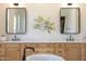 Elegant bathroom featuring double sinks, framed mirrors, and wood cabinets at 2668 E Kingbird Ct, Gilbert, AZ 85297