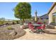 Charming backyard with outdoor dining area, gravel landscaping, and mature desert trees at 3055 N Red Mtn # 156, Mesa, AZ 85207