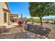 Serene backyard featuring a patio area, outdoor dining set, mature trees, and natural desert landscaping at 3055 N Red Mtn # 156, Mesa, AZ 85207