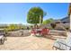 A spacious backyard featuring a stone patio, lush green tree, and comfortable seating for outdoor enjoyment at 3055 N Red Mtn # 156, Mesa, AZ 85207