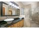 Main bathroom featuring a double sink vanity, granite countertops and a glass shower at 3055 N Red Mtn # 156, Mesa, AZ 85207