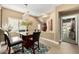 Glass-topped dining table with four chairs, modern chandelier, and adjacent room view at 3236 E Chandler Blvd # 2053, Phoenix, AZ 85048