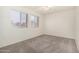 Well-lit bedroom featuring two windows and carpet flooring at 3513 W Danbury Dr, Glendale, AZ 85308