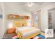 Cozy bedroom featuring a yellow bed frame and built-in shelving at 3513 W Danbury Dr, Glendale, AZ 85308