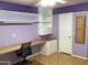 Purple bedroom with a ceiling fan, built-in shelves, and large desk workspace at 3554 E Camino Cir, Mesa, AZ 85213