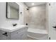 Updated bathroom with gray vanity, white bathtub, and modern tile at 4432 E Belleview St, Phoenix, AZ 85008