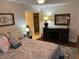 Bedroom featuring a large bed with decorative pillows, dark wood floors, and a carved wood console table at 5132 N 31St Way # 112, Phoenix, AZ 85016