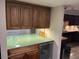 Kitchen wet bar area featuring granite countertops, dark wood cabinets, wine fridge and decorative glassware at 5132 N 31St Way # 112, Phoenix, AZ 85016