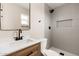 Modern bathroom with gray tiled shower, updated fixtures, and a vanity with a wood cabinet at 5313 W Osborn Rd, Phoenix, AZ 85031