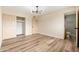 Bright bedroom with wood laminate flooring, a modern ceiling fixture, and a closet with sliding doors at 5313 W Osborn Rd, Phoenix, AZ 85031