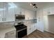 Updated kitchen with white cabinets, stainless steel appliances, and gray tile backsplash at 5313 W Osborn Rd, Phoenix, AZ 85031