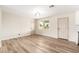 Empty living room featuring wood flooring, natural light and adjacent modern kitchen at 5313 W Osborn Rd, Phoenix, AZ 85031