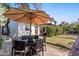 Outdoor dining area featuring a table with an umbrella, lush green lawn, and beautiful landscaping at 6811 E Juniper Ave, Scottsdale, AZ 85254