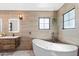 Bright bathroom featuring a standalone tub, unique tile, and natural light from the window at 6811 E Juniper Ave, Scottsdale, AZ 85254