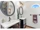 Bathroom featuring double sinks, decorative mirrors, and stylish cabinets at 6811 E Juniper Ave, Scottsdale, AZ 85254