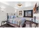 Cozy bedroom featuring wood floors, decorative sconces, and a window with shutters at 6811 E Juniper Ave, Scottsdale, AZ 85254