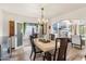 Charming dining room with a view to the backyard, stone table, and chandelier at 6811 E Juniper Ave, Scottsdale, AZ 85254