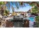 An outdoor kitchen near a pool offers the perfect setup for entertaining and alfresco dining at 6811 E Juniper Ave, Scottsdale, AZ 85254