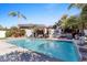 A sparkling pool surrounded by lush landscaping with a patio, outdoor kitchen, and water features at 6811 E Juniper Ave, Scottsdale, AZ 85254