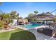 Resort-style pool area featuring a waterfall, tanning ledge, and covered lounge area for ultimate relaxation at 6811 E Juniper Ave, Scottsdale, AZ 85254