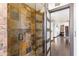 Luxurious shower with rainfall showerhead, stone tile, and glass door at 6811 E Juniper Ave, Scottsdale, AZ 85254