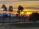 Scenic golf course view featuring palm trees silhouetted against a vibrant sunset sky at 7027 N Scottsdale Rd # 150, Paradise Valley, AZ 85253